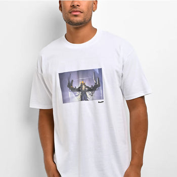 A man wearing a white crew-neck t-shirt with a rectangular graphic print on the chest depicting a sci-fi robot or mecha figure, set against a plain light gray background.